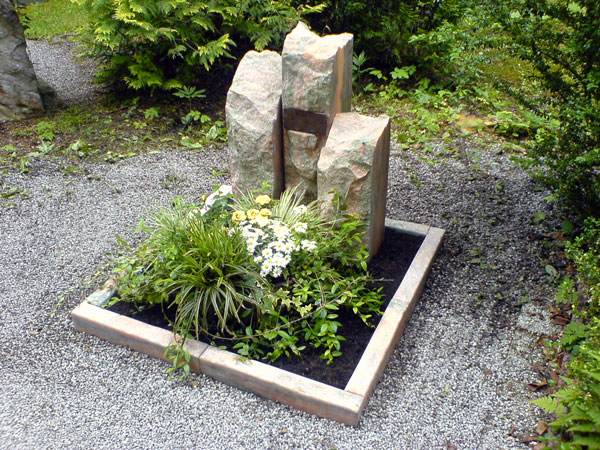 EIn Grabstein aus drei einzelnen, an der Vorder-und Oberseite behauenen Steinen.